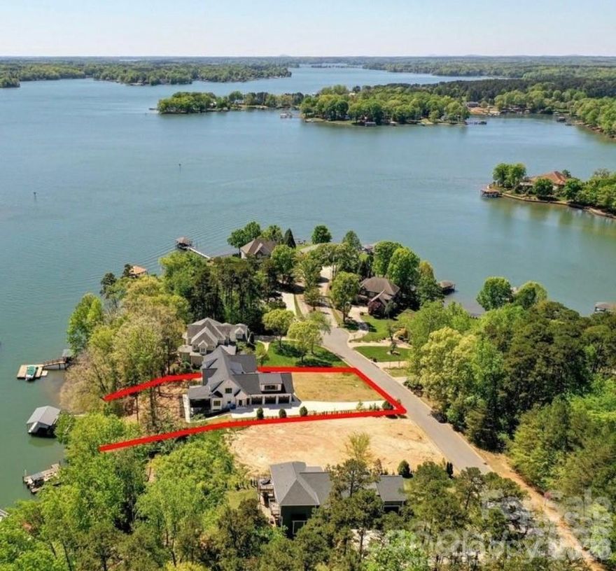 A 2026 appraisal shows the house appraises for $2,495,000. Recent inspection was performed and all repairs have been completed. Experience refined waterfront living in this meticulously crafted custom home, where no detail was overlooked and every finish reflects exceptional quality. At just 2 years old, this residence offers the rare opportunity to enjoy like-new construction without compromise.
From the moment you enter through the custom iron and glass doors, you’re welcomed into a light-filled, open-concept design anchored by a stunning vaulted great room with exposed wood beams, a gas fireplace, and a dramatic wall of windows showcasing peaceful water views.
Designed for both everyday living and effortless entertaining, the chef’s kitchen features custom cabinetry, quartz countertops, an expansive island with bar seating, and a butler’s bar connecting to a private dining space. Step outside to the screened porch and deck—perfect for morning coffee or evenings overlooking the water.
The main level includes two spacious primary suites with a luxurious shared bath, offering flexibility and comfort. Upstairs, you’ll find generously sized bedrooms, each with private baths, along with an oversized bonus room and an open loft that enhances the home’s airy, connected feel.
The walk-out basement expands your living space with a family room, exercise area, additional bedroom suite, office, flex/craft room, and abundant storage—all designed with the same attention to detail found throughout the home.
Outside is where this property truly shines. Enjoy long summer days on the water from your private dock, complete with a covered boat slip and dual lifts—ideal for boating, swimming, and making lasting memories. The setting offers both fun and tranquility, tucked away from marina and main channel traffic for a more private experience.
Car enthusiasts and hobbyists will appreciate the impressive 1,000+ sq ft three-car garage with easy access to all mechanical systems. A whole-home filtration system, including instant hot and cold at the kitchen sink w/ reverse osmosis, adds another layer of thoughtful upgrades.
This is more than a home—it’s a lifestyle defined by quality, comfort, and unforgettable waterfront living.