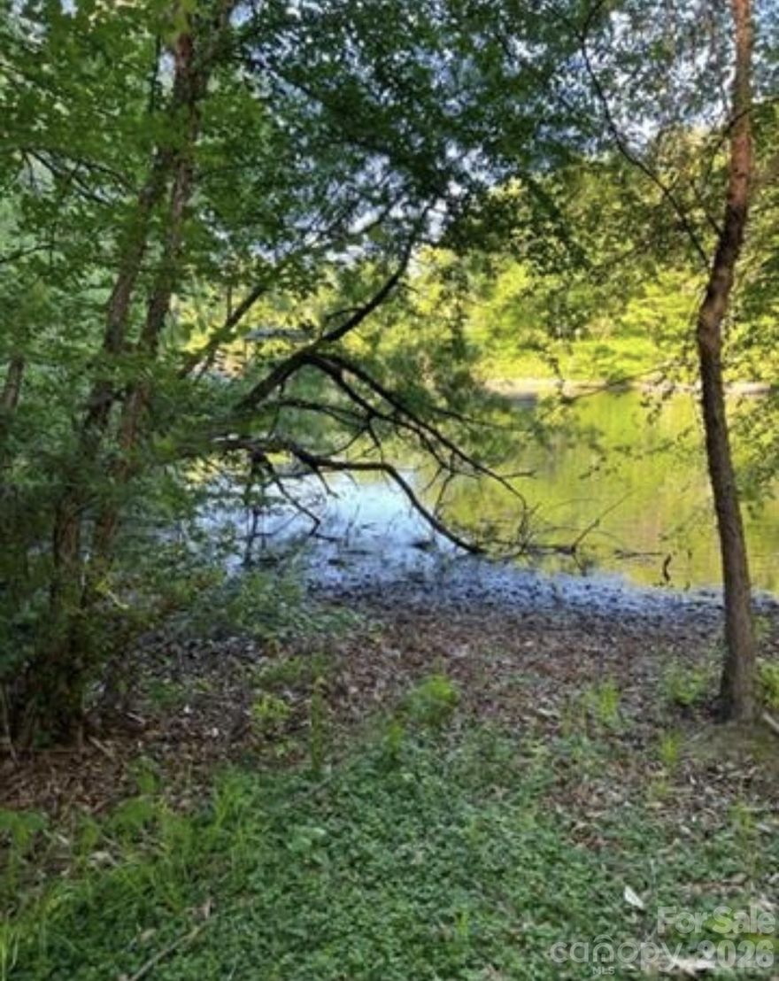 Escape to the quiet side of Lake Norman with this beautiful 0.47-acre wooded lot tucked away on a private road. Surrounded by mature trees and natural shoreline, this property offers peace and privacy in a serene lakefront setting.

While no dock is permitted, you’ll still enjoy direct water access just steps away—perfect for launching a kayak, paddleboard, or canoe for sunrise paddles and quiet afternoons on the lake. The shallow-water cove creates a calm, family-friendly place to wade or relax by the shore.

This property combines the charm of lake living with the freedom to design your own getaway. Whether you’re envisioning a weekend retreat or a year-round residence, this rare find offers an affordable way to experience Lake Norman living.