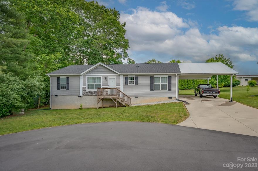 This beautifully maintained newer 3 bedroom, 2 bathroom Norris manufactured home is located in a very nice 55+ community with low HOA fees. This one level home is at the end of a cul-de-sac with a large fenced in back yard. The open floor plan makes the home feel very roomy and the drywall walls throughout the home are a very nice upgrade. The primary bedroom is spacious and the primary bath includes a tub and shower. The kitchen is equipped with tons of storage space and nice appliances. The attached carport has room to park two vehicles and there is also additional room to park in the driveway. This home is conveniently only a short drive to downtown Hendersonville, shopping and restaurants. Schedule your showing today!