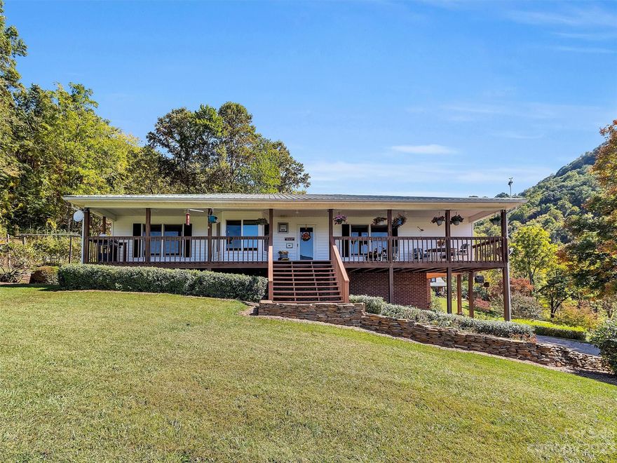 Nestled in a serene country setting, this charming 3BR/3BA home is surrounded by rolling hills & majestic mountain views. This private & well maintained home is a haven for those seeking peace & tranquility.  It features an open floorplan, living room w/ fp, ample natural light & a kitchen with beautiful wood cabinets. The bedrooms are cozy & inviting. Wake up to the sight of sun-kissed mountains & breathe in the crisp country air. The basement boasts a wood-working shop, full bath, a bonus room & an oversize garage with lots of storage. One of the highlights of this property is the expansive 24x40 outbuilding. This versatile space is suitable for RV storage and other vehicles or a variety of purposes.  Enjoy year round living with a private setting, covered front porch, beautiful rock waterfall/Koi pond  & mtn views. Leave the fast-paced world behind  & enjoy a place that embraces the simple pleasures of nature & country living. Only minutes from downtown Maggie Valley & Waynesville.