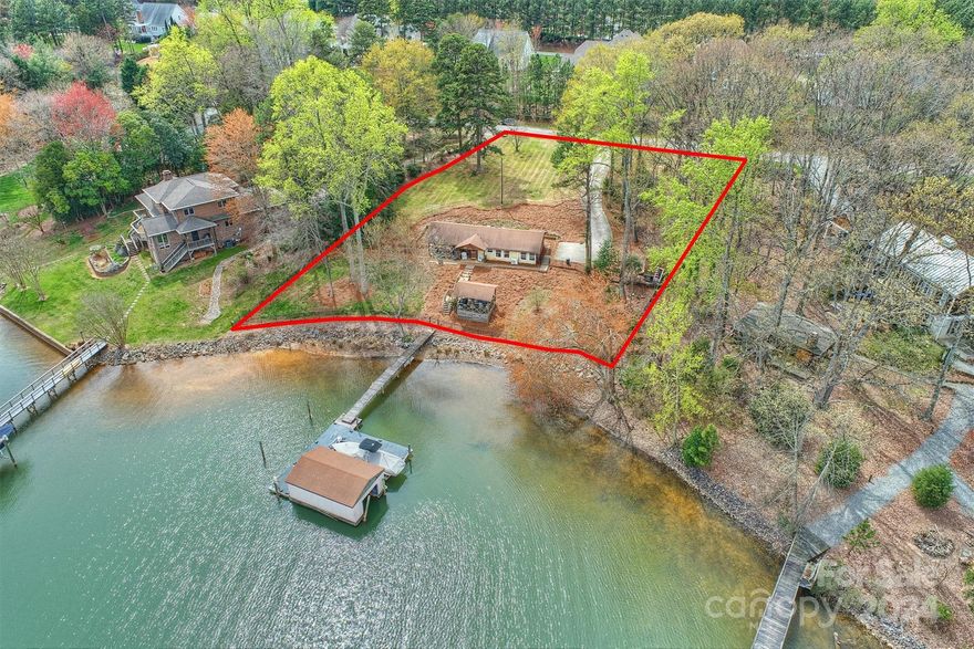 Fabulous waterfront building lot in PRIME NO HOA location surrounded by The Point! Privacy, beauty, no restrictions, low cost of ownership and one of the most desirable streets in Mooresville. This sweet cabin is the perfect weekender or building site for your dream home on Lake Norman. Gorgeous lot gradually slopes to lake with approximately 168 feet of shoreline on a large, deep water cove with glorious lake views, private dock, rare boat house and stable shoreline. Enjoy the beauty of being on a large water cove that is safe for your boat and play, yet just a minute out to main channel. Bring your own builder anytime or enjoy the existing cabin for years to come! Surrounded by newer custom construction and estate homes, this beautiful property offers so many possibilities. Tremendous investment and potential for greatness. Do not miss the opportunity to own your slice of lakefront heaven on Lake Norman!
