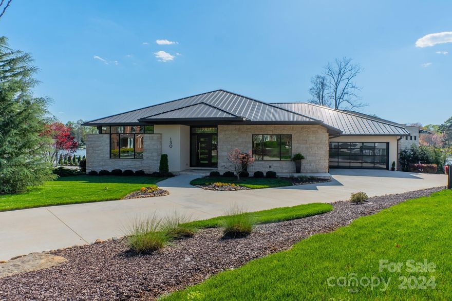 A rare find on beautiful Lake Norman all on ONE floor. As you walk through the custom front door, notice the beautiful Brazilian pecan floors that open to floor-to-ceiling windows that bring lake views into the home. Modern, functional, inviting, and warm, are the ways to describe this house. An open kitchen with a large pantry, welcomes you with warm walnut cabinetry and stainless-steel appliances. The primary suite is encased with a floor-to-ceiling corner window wall and an attached flex space. Primary bath boasts a huge, walk-in shower, double vanity, and oversized soaking tub. Outside is an expansive, covered entertainment area with 3-sided stone fireplace. The area overlooks both the raised pool area and lake where you can take in spectacular sunset views. The property boasts over 200’ of water frontage with a rare 35’ setback and private dock with cable lift. Car enthusiasts will love the oversized 4-car garage with epoxy floor and glass garage doors. Come see this rare find.