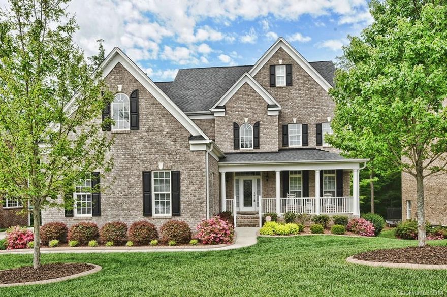 Brick and vinyl home w/ professional landscaping, irrigation, walkout basement.  Heavy custom moulding t/o main floor with hardwood floors t/o! Kitchen w/ granite counters, SS appliances inc 5-burner gas cooktop, wall oven/microwave combo. 42" cabinets. First floor guest suite w access to full bath. 2-sty great room w/ huge palladium style window, gas log fireplace. Upstairs is spacious master ste w/ tray ceiling & ceiling fan, dual closets.Basement w/ stained concrete floor,wet bar, full bath.