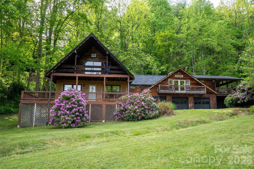 A rare opportunity for a true multi-generational living arrangement just minutes from WCU! This 4-bedroom plus flex space, 3-bath home offers TWO separate-yet-joined living spaces – each with its own full living amenities. Located near the top of the Village of Forest Hills, with views of the valley and mountains, you’ll be impressed with this unique, updated home. A new roof and skylights (2023), new hvac systems (2020), two new water heaters (2023) and fresh neutral paint throughout, provides added peace of mind.

The main part of the home spans two floors while the “apartment” side resides over the three-car garage. Separate entrances & separate decks provide privacy as well as fabulous entertaining opportunities! The wraparound deck on the main side is ready for your hot tub with electrical already in place. As you enter the main living area on the ground level, you’re greeted by a large stone fireplace with gas insert, windows on every wall, an open concept kitchen/living room leading to a guest bedroom, updated full bath (check out the awesome shower!), laundry room and office/flex space with adjoining mudroom that is perfect for storage, extra fridge/freezer or drop zone. So much versatility!

Upstairs you’ll find a large primary bedroom with its own quaint balcony perfect for watching the sun come up or shooting stars on a clear night. It also has a unique loft area large enough for sleeping or storage. The second upstairs bedroom is oversized with 3 closets. A second full bath services both bedrooms.

The second living quarters is a real gem! Open concept and full of light with multiple skylights, this updated one-bedroom/one bath section of the home includes a new tiled shower and vanity, new high-end lvp flooring, new butcher block countertops, vaulted ceiling, laundry closet and a bedroom with a closet pass-through to the main house that can be locked or not. This home is one of a kind – designed to accommodate a variety of lifestyles. Only five minutes from WCU and the new recreation center.