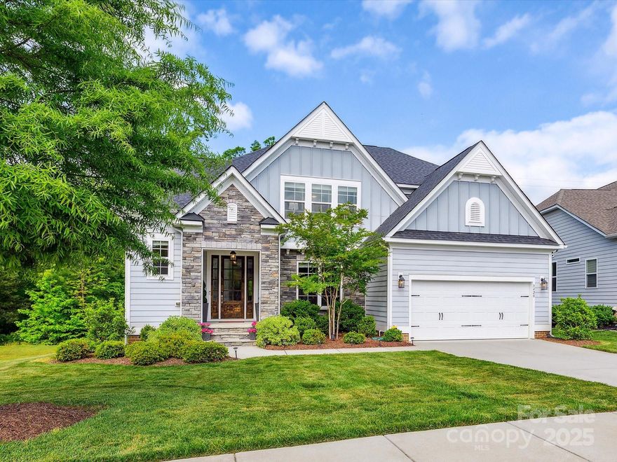 As you enter you are greeted by custom millwork and a two story landing.  The floorplan is open and thoughtfully designed; an elegant dining room flows into the great room, where a cozy fireplace is flanked by gorgeous built-ins.  The gourmet kitchen features an oversized island, deep drawers for pots and pans, soft close cabinetry with pull-outs and a walk-in pantry.  Enjoy the breakfast nook surrounded by windows looking out at the gorgeous wooded lot, have coffee on the covered porch or relax on the patio; the lot next door is common property and great open space. Extra flexibility w/a bedroom and full bathroom downstairs in addition to the powder room.  At the top of the stairs is a great area for work or play.  The primary retreat is a dream, with a view of the woods, tray ceiling and chandelier, and huge walk-in closet.  The primary bath features dual vanities and a spa-like shower.  Neighborhood pool, clubhouse, playground, pond w/dock & trails; highly rated Fort Mill schools.