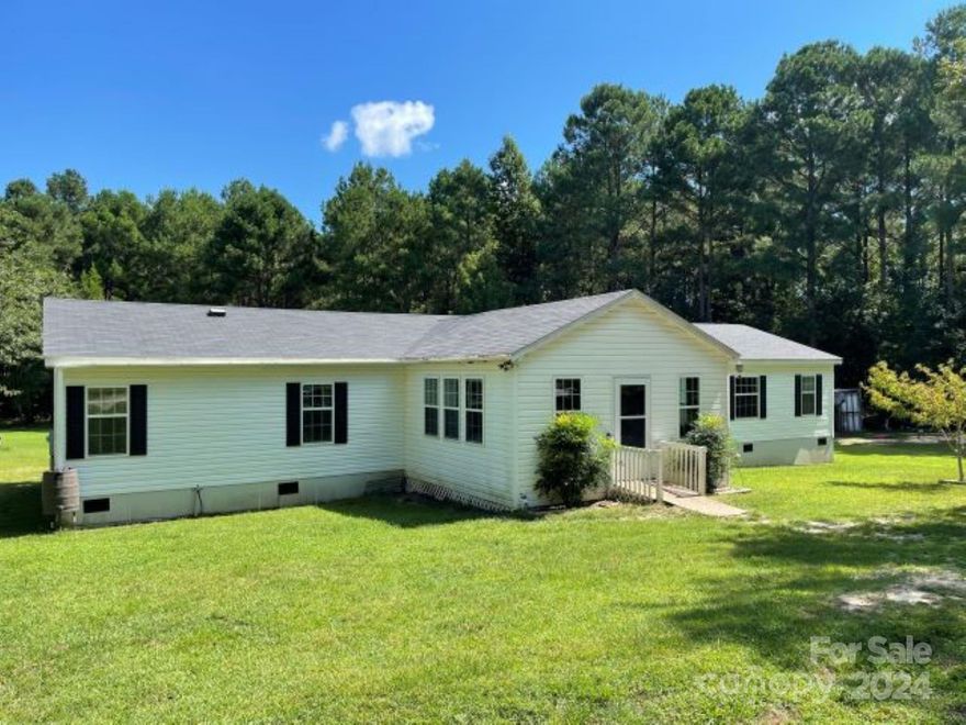Big acreage with water? Privacy off main road? Plenty of room to roam? Lots of outdoors usable areas for storage and animals? This property checks off so many boxes. Property has 2 Garden Areas, Fenced areas for animals/chicken coops, Greenhouse w/ wood burning stove, Dog Kennels, Double Carport, 12'x20' 4' Kayak(brand) Pool, Large 30'x48' Building w/4 garage doors. Seller owns half of approx 7 ac year-round pond. 
With approx. 2128' square footage inside,this Scott-Built home has 4 Bedrooms, 2 Full Baths, Large walk-in living room, Walk-in Kitchen with large island. Master bedroom is offset opposite end of rest of bedrooms.  Laundry Room, Open Floor Plan, Unfinished 16'x17' front porch area.