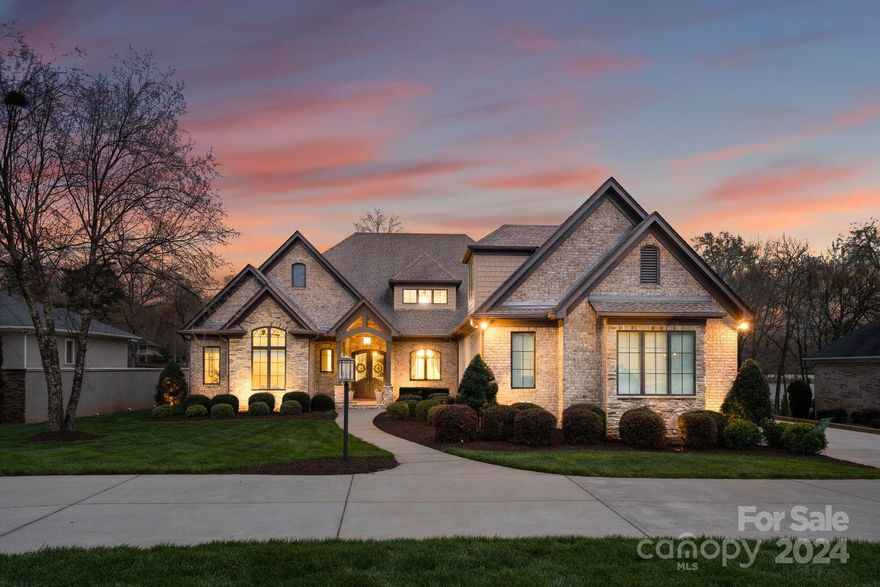 Discover luxury and serenity at this custom-built, brick waterfront estate nestled on the shores of Lake Wylie in Belmont, NC. Step inside to find expert craftsmanship including a chef's kitchen outfitted with top-of-the-line Thermador appliances and finishes, solid wood doors, coffered and cathedral ceilings. The sunroom, with its fireplace, offers a tranquil space to relax and enjoy panoramic lake views. Outdoor living is redefined here, with a backyard patio featuring a built-in Viking grille and fireplace, alongside a spectacular pool with grotto, hot tub, and waterfall, creating an oasis for relaxation or hosting gatherings. The property sits on a beautifully manicured, flat lot, with a covered boat dock equipped with three full-power automatic lifts. Current owners added second living space on upper level (1616 sq ft), to include full kitchen and living area! Please see attached feature list. Boat and jet skis to convey with acceptable offer!