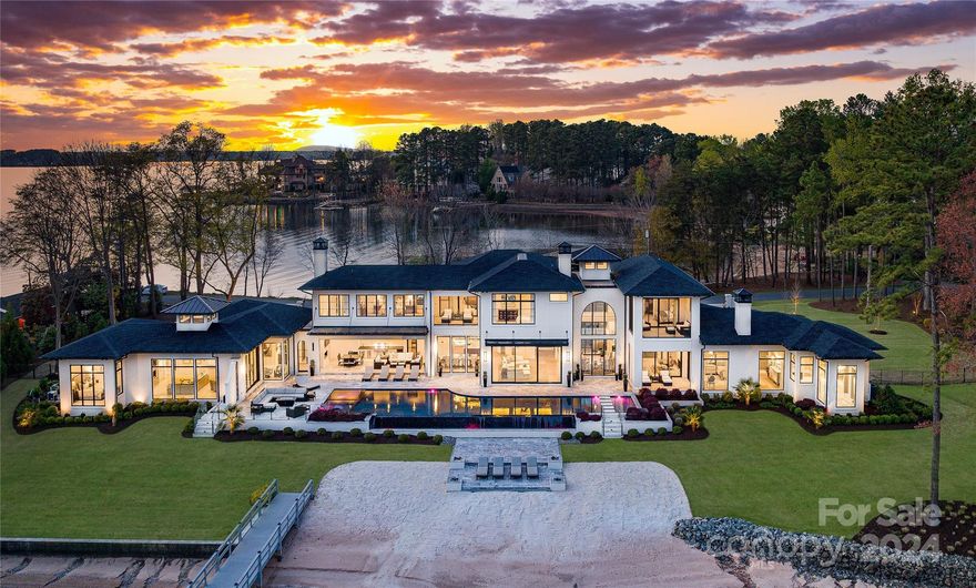 This architectural marvel truly epitomizes luxury living, is meticulously crafted and stands as a testament to refined elegance and sophisticated design. Situated on a sprawling 1.44-acres, with its stunning 365 feet of shoreline and sandy beach, this home seamlessly blends indoor and outdoor spaces with floor to ceiling windows and retractable doors to further enhance breathtaking water views from the front and back of the home. Amenities including a gated entry, Control4 automation, and an artistically designed glass wine cellar. A guest casita and lanai with retractable screens provide the perfect spot for outdoor relaxation but the true highlight lies with outdoor kitchen, infinity pool, and a large outdoor living area with panoramic views adding to the property's allure as a rare gem. Every detail has been meticulously curated for the discerning buyer. Whether you're seeking tranquility, sophistication, or simply the finest in luxury living, this property delivers on every front.