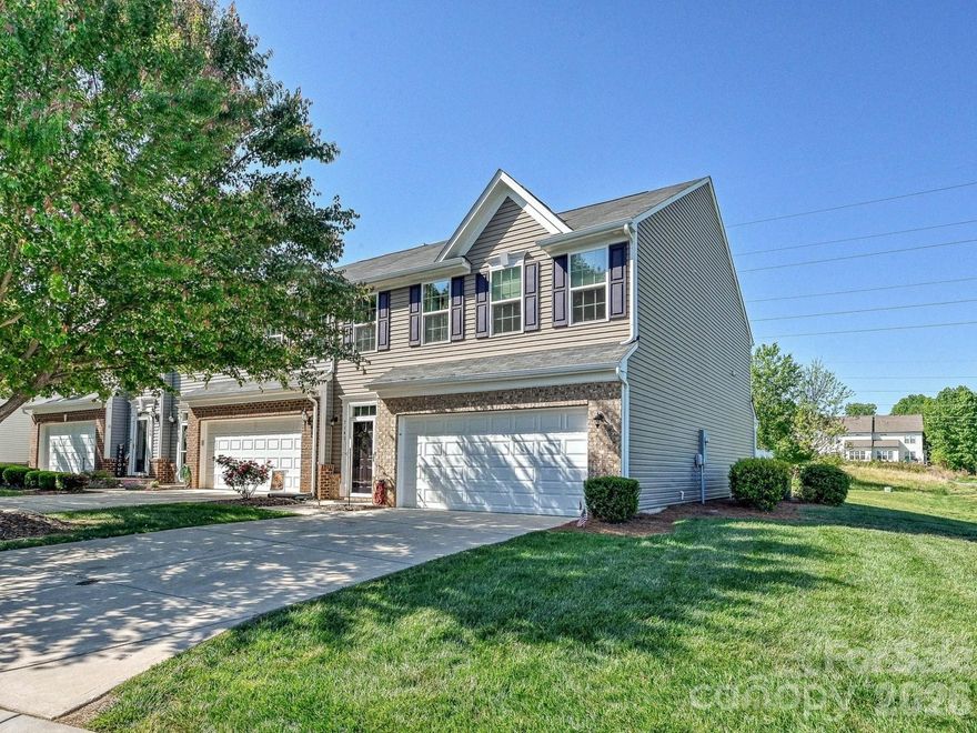 End-unit townhome, former builder model, set on an open common-area homesite in Mariners Pointe at Smithstone. The model-home details show throughout: upgraded finishes and designer selections including a painted tray ceiling in the primary suite, and a finished garage with recessed lighting. Further enhancements by the current owner include hardwood stair treads and an expanded, covered patio as well as built in cabinets in the dining area. The main level flows from a welcoming foyer past a convenient powder room into an open kitchen, dining, and living space anchored by a large granite island. White cabinetry, stainless appliances, pendant lighting, and hardwood floors carry through the primary living area. A covered expanded paver patio opens off the back for true outdoor living, with open green common area behind the home. Upstairs, the primary suite features the painted tray ceiling, en-suite bath with dual vanity and walk-in shower, and generous dual walk-in closets for extra storage. Two additional bedrooms, a full hall bath, a dedicated laundry room, and a central loft landing complete the second floor. The loft works equally well as a home office, reading nook, or secondary sitting area. The attached two-car garage is finished with a coated floor, offering everyday convenience plus room for storage, a workbench, or hobby space. An extended driveway provides comfortable parking for additional vehicles beyond the garage, and end-unit positioning means added privacy. Mariners Pointe at Smithstone residents enjoy a clubhouse, outdoor pool, available RV and boat storage, and quick access to Lake Norman, Highway 16, and everyday Denver conveniences. A rare chance to own the former model, meticulously maintained, with upgrades already done.