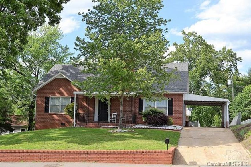 Spacious 4BR/2.5BA brick home just steps to downtown Morganton. Property includes adjacent partially fenced lot, so there is plenty of room to play! Large living room with fireplace and hardwoods and large eat-in kitchen. Two bedrooms, 1 full bath and 1 half bath on main level. Two bedrooms and full bath upstairs. Unfinished basement. Driveway continues all the way through to Jefferson Street. New roof and two heat pumps - one for main level and one for 2nd floor - in 2012. Spray foam insulation in walls and ceiling upstairs for energy efficiency.