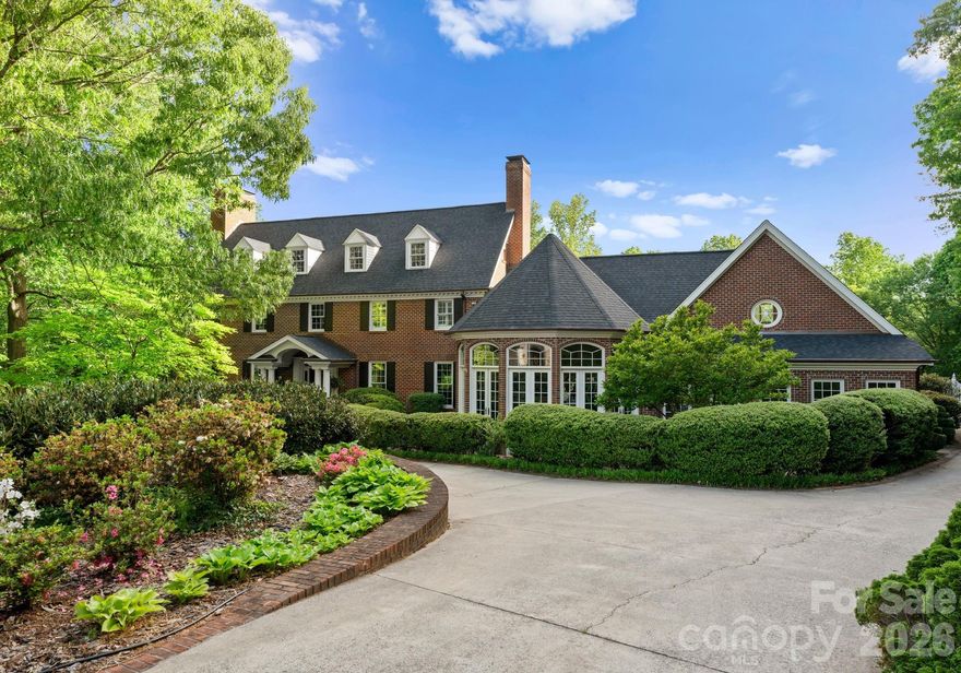 Discover a striking masterpiece of timeless luxury in the heart of Northwest Hickory, NC. Perfectly positioned for both tranquility and accessibility, this prestigious residence is located just around the corner from the Lake Hickory Country Club, 30 miles from the scenic Blue Ridge Mountains (Blowing Rock), and an hour from the bustling energy of Charlotte. This captivating two-acre estate has unparalleled grounds featuring European inspired gardens, a professional greenhouse, a brick wine cellar, and paths that meander to a beautiful park like grassy area by a live stream with boulders and two bridges. This prestigious residence boasts a main floor, stunning primary suite with vaulted ceilings, two full baths and two custom walk-in closets, a chef's kitchen with dual islands and a BlueStar range, expansive eat-in dining area with a wall of windows overlooking the rear terrace, a breathtaking solarium, multiple living rooms with fireplaces, a second primary bedroom suite, media room, spacious art studio and more. Offering an unmatched blend of natural beauty, refined craftsmanship, and inspired living, this estate is a rare opportunity to own one of the area’s most distinguished and enchanting properties.
