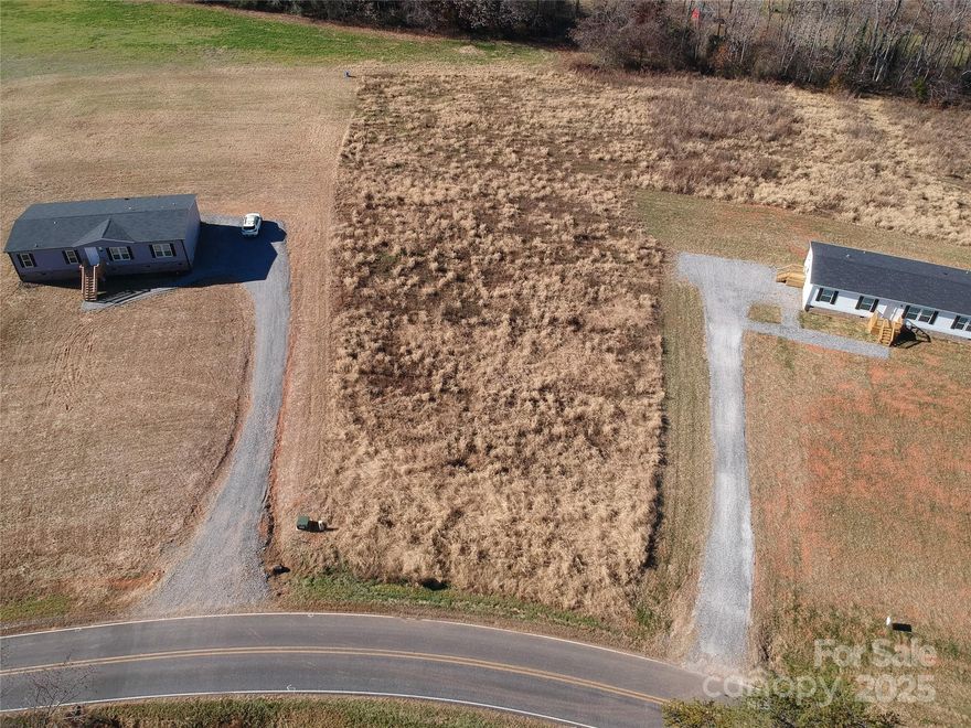 Over a one acre lot in the countryside but just 3 miles to I-77. Located in the quiet countryside of North Iredell. Just minutes from Union Grove or Harmony or a short drive to Statesville, Mocksville or Wilkesboro. The lot is already cleared so it is ready to build on.  The septic permit has already been acquired through the County, saving you a bunch of time and money! We can also build on the lot for you.  Stick built complete packages with the lot start at $325,000.  Double wide packages with the lot start at $225,000.