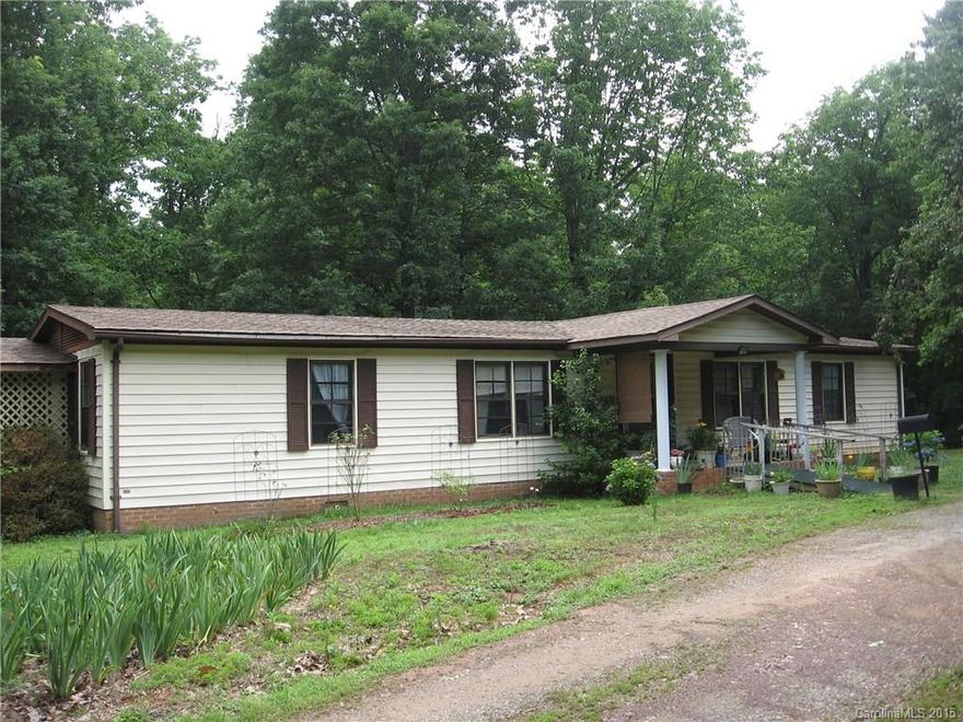 Spacious 3 bedroom, 2 bath dbl. wide on approx. .5 acre featuring 2 car carport attached, 2 car garage detached, screen back porch, laminated wood flooring throughout, linoleum and/or tile in kitchen and bathrooms