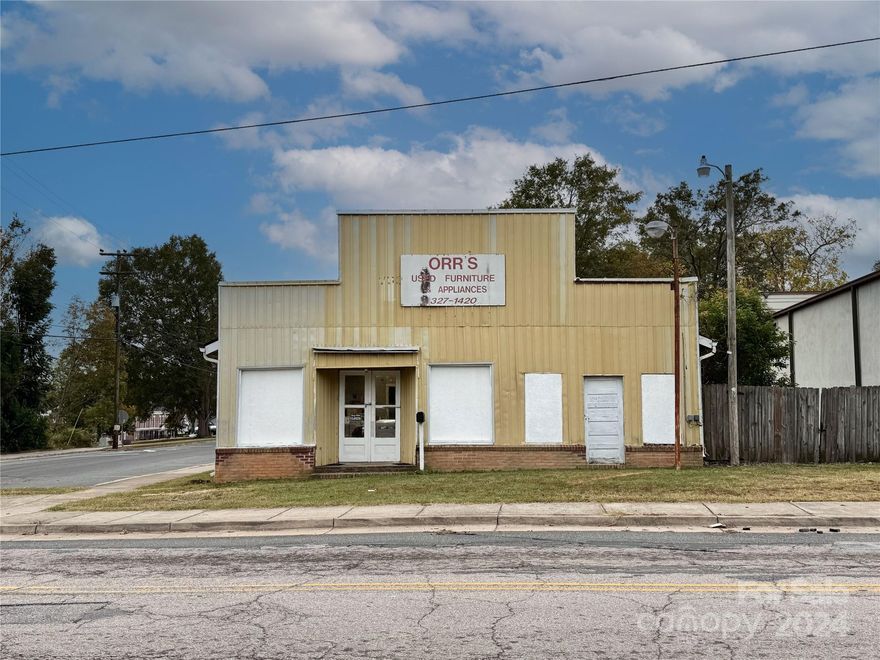 This commercial building offers 2,909 sq ft of versatile space and is situated on a corner lot close to downtown Rock Hill. The property features a large showroom, ideal for displaying products or creating an open workspace, along with multiple storage areas to accommodate inventory or equipment. A half bath is also included for convenience. While the building is in need of updating, it presents a valuable opportunity to customize and renovate to fit your business needs.