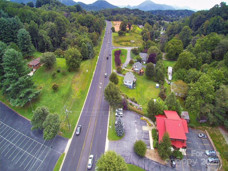 1.8 acres of Prime Commercial Property Located in Waynesville, NC with Approx. 330+ ft. of road frontage on Russ Ave. which is the major commercial corridor for this area. The property currently has a 3/2 Brick Ranch home on site. It could be utilized as is or removed. The site is zoned Dellwood Residential-Medium Density-Mixed Use.  City water and sewer on site.