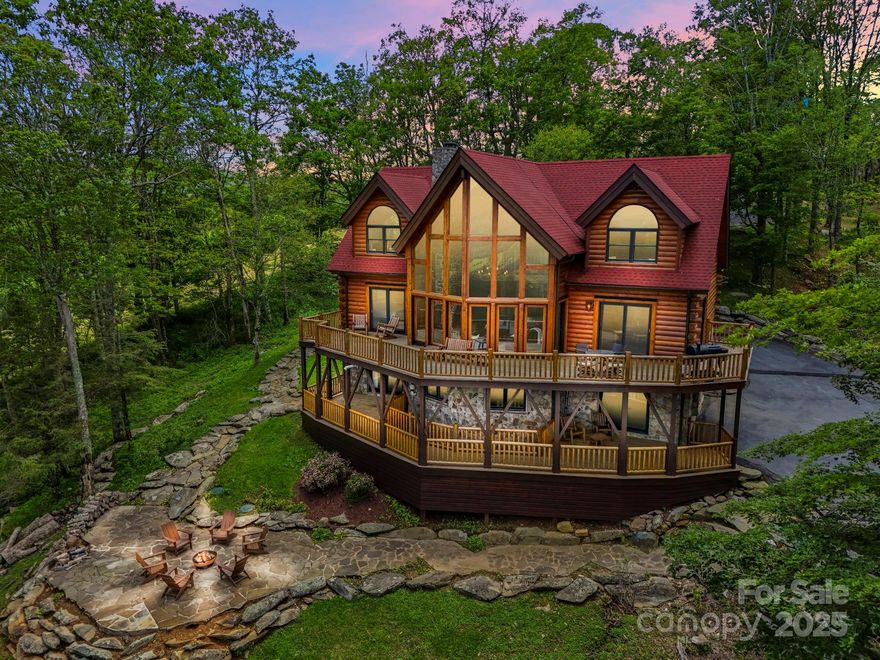 Tucked into the mountains just minutes from Banner Elk, this exceptional custom log home offers the ultimate blend of rustic luxury, privacy, & sweeping long-range views. Offered fully furnished, the home welcomes you with wide plank heart of pine floors, soaring cathedral ceilings, & a dramatic stone fireplace framed by floor-to-ceiling windows to take in the breathtaking views! The kitchen is a dream—custom cabinetry, marble countertops, & open flow into the dining area. The spacious main-level primary suite features sliding doors to balcony, a jetted tub, tiled shower & walk-in closet. Upstairs, 2 vaulted suites & a loft capture the long range views. Walk-out lower level offers a bonus suite & a heated/cooled game room (800+sf not in HLA), plus detached garage. Outdoor living with expansive decks, stone patio, & firepit. Includes 3 additional buildable L/R view lots. Whether you're seeking a mountain retreat or investment, this one checks every box. See docs for seller improvements.