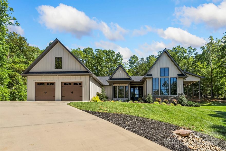 Tucked away on a peaceful acre in one of Morganton’s most desirable small developments, this 2022 custom-built modern ranch is a true showcase of craftsmanship and comfort. Designed to embrace its natural setting, the home features stone and cement siding accented with cypress posts, 42 Jeld-Wen windows, and 3/4" tongue-and-groove hardwood floors throughout.  Inside, the open-concept layout welcomes you with a chef’s kitchen boasting high-end appliances, oversized gas range, a 10’ island, walk-in pantry, and custom cabinetry topped with granite surfaces. The dining area—with its striking custom granite banquette table for 10—flows into a spacious family room and out to a large covered patio for effortless indoor-outdoor living. A separate den with vaulted ceiling and fireplace leads to a charming side porch, perfect for morning coffee or unwinding at day’s end. Each of the 3 bedrooms enjoys a private ensuite bath and walk-in closet, with the main-level primary retreat offering vaulted ceilings, patio access, and a spa-like bath filled with natural light, custom cabinetry, and direct access to the laundry suite. Additional highlights include custom metalwork throughout, extensive storage, a 2-car garage with a drop zone entry right off the kitchen, and timeless details that make this home truly one of a kind. Convenient to downtown Morganton and I-40, this home blends modern luxury with peaceful living in a setting that feels both private and connected.