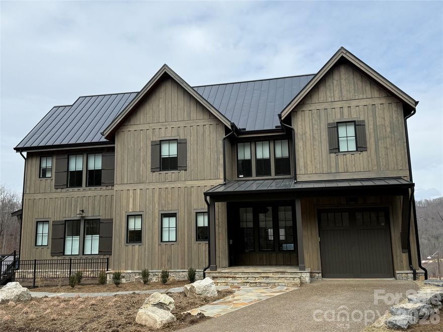 Nestled in the serene Balsam Mountains of Western North Carolina, this exquisite newly constructed residence offers sweeping views of both the Arnold Palmer–designed golf course and majestic mountain landscapes. The home features 5 spacious bedrooms and 5½ luxurious bathrooms. The gourmet chef’s kitchen is designed for culinary excellence, featuring luxury Wolf and Sub-Zero appliances, quartz countertops, and custom cabinetry. The open concept layout seamlessly connects the kitchen to the living and dining areas, perfect for entertaining. The covered outdoor living space is equipped with its own kitchen and grill, ideal for al fresco dining and gatherings. Balsam Mountain Preserve is a private 4,400 acre club community with 3,200 acres of conservation land and completed amenities featuring golf, equestrian, scenic trails, tennis and dining. The stunning new facilities at Doubletop Village, including the Summit House Restaurant and Mine Tavern, are now open to members and their guests.