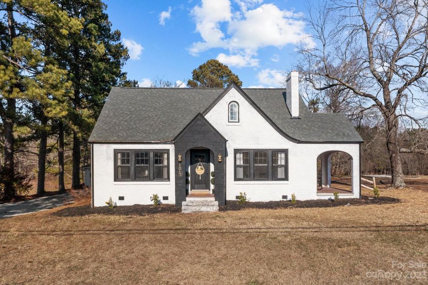 WOW! Stunning home, custom design, and excellent location! Welcome to this beautiful home situated in the desirable East Rowan district, conveniently located within minutes of Granite Quarry town center. You'll love the white brick and modern black trim. The arched, covered side porch is perfect for enjoying your morning coffee or relaxing in the evening. The moment you step inside, you'll be impressed by every detail. The open floor plan features a large living room with a beautiful fireplace, an expansive dining room which leads into the oversized kitchen with a nice island to provide plenty of prep and sitting space and a walk-in pantry. The sage green accents pair perfectly with the wood finishes keeping the design modern and trendy. Each room is very spacious with plenty of natural light. You won't run out of space with a large basement and huge unfinished attic complete with additional rooms for storage. The yard is inviting with mature trees for privacy. Don't miss this one!