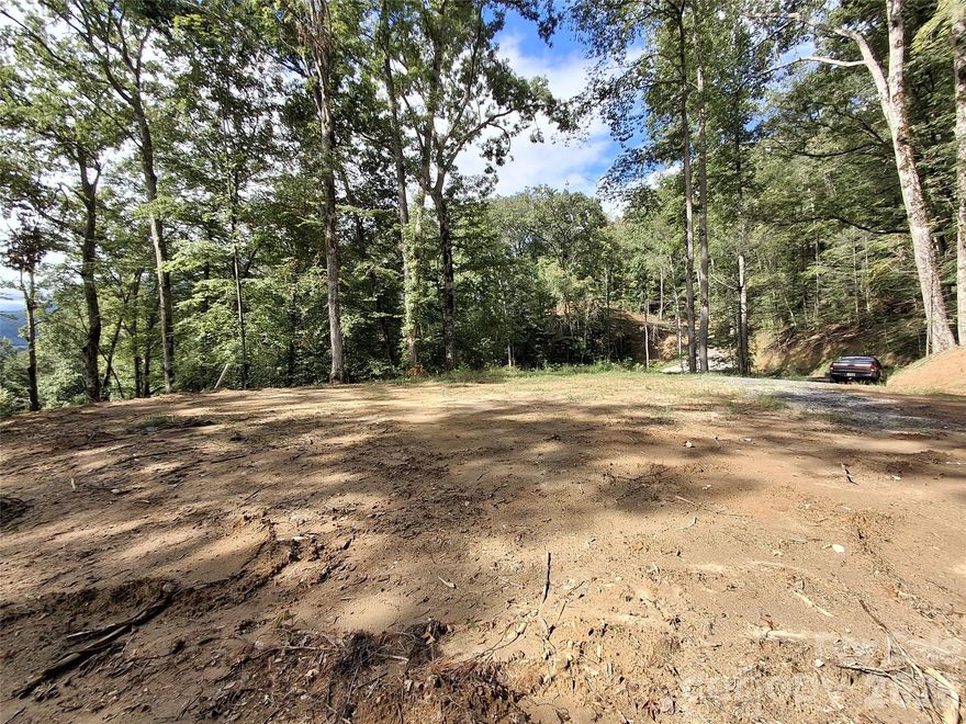 Perched above town, this private mountain retreat is accessed by a short scenic gravel driveway lined with trees, opening up to breathtaking mountain and city views. The elevated setting provides a peaceful, tucked-away feel while still being incredibly convenient — just 2 minutes from Bryson City Bakery, Bryson City Outdoors Brewery, and Pasqualino’s, 3 minutes to the Post Office, Great Smoky Mountains Railroad and Hallmark-like downtown, 5 minutes to Ingles Grocery Store and Darnell Farms and in 10 minutes you are hiking in the Great Smoky’s National Park. World renown white water rafting and the Nantahala Outdoor Center is a scenic 15 minute drive away. 

***Owners plan to pave the area near the entrance to their home at 75 Bacon and the initial turnoff from Bacon Dr. to the lot. Work is planned for April. 

Every detail has been prepared for your dream build: city water, underground power, and septic are already in place, along with a quaint professionally installed house pad. This thoughtful groundwork ensures a smooth start to construction, whether you envision a cozy mountain getaway, an income-generating vacation rental, or your forever home. Through a natural opening in the trees, you can enjoy glimpses of town, with expanded mountain and city views revealed during the winter months - come check it out today!.

It’s the perfect blend of natural beauty, privacy, and easy access to everything Bryson City and the Smokies have to offer.