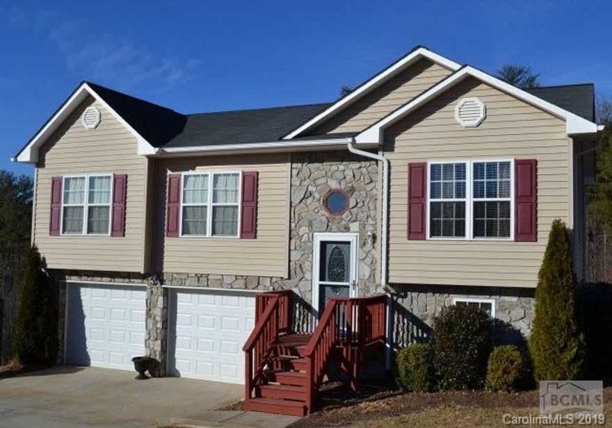 Immaculate and well-maintained 3BR/2BA home located just minutes to pristine Lake James!  Neutral siding and warm stone exterior provide great curb appeal in this desired neighborhood.  Richly hued scraped oak laminate floors found throughout entry, kitchen, living and common areas.  Vaulted ceilings and numerous windows allow abundant natural light.  Open kitchen has been designed for even the most discerning cook featuring gorgeous cabinetry, granite look counters, chef's prep island set at a unique angle and large pantry.  Modern appliances include three door refrigerator; smooth service range/oven; built in microwave and dishwasher.  Dining room opens to entertaining deck in back.  Spacious master suite features walk-in closet and full bath with a spa feel and shower/tub combo.  Two additional gracious size bedrooms and beautiful full bath on main level.  Wonderful family room on lower level makes a great media/exercise/office space.  Double car automatic garage. Easy to show.