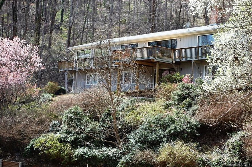 BUYERS' FINANCING FELL THROUGH!! MOTIVATED SELLERS. Tons of space & privately located on a quiet lane convenient to downtown Tryon.  Lots of living space, 2 wood burning fireplaces, workshop attached to garage. Fully finished basement boasts 2BR/2BA plus partial kitchen, large rec rm & w/ ext entrance could easily be separate living quarters. Sits high atop a hill w/ beautiful granite face & rock formations. Trickling stream & mature landscaping add to the special setting.