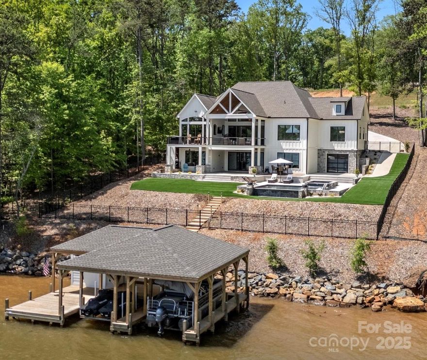 Situated w/ panoramic views on main channel of Lake Tillery in Edgewater, this home embodies modern craftsmanship, luxury finishes, and high-end spaces that define sophisticated living. Boasting 5+ bed, 6 1/2 bath, a 4car plus golf cart garage, this property has abundant space to host family and guest gatherings. The master suite is a private haven of elegance, heated tile flrs and walk-in closet with laundry for ultimate convenience. At its heart is a chef’s kitchen, with premium finishes and adjoining scullery, for culinary endeavors and entertaining in style. Additional highlights include a state-of-the-art home theater, epoxy-finished basement floors, and extensive storage solutions, flawlessly combining style and practicality. Step out to an outdoor oasis, heated infinity pool and spill spa, low-maintenance turf to enhance space, two-slip boathouse w/ lifts for seamless lake access. This exceptional property is not just a home, but a lifestyle tailored to elevate lakeside living.