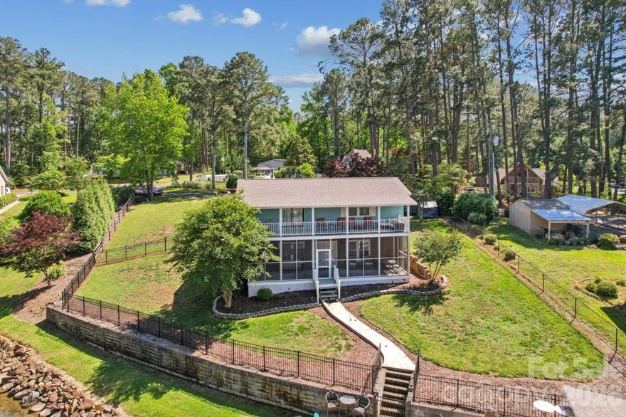 Beautiful Lake Tillery home located in a peaceful cove on a double lot. It features a covered double boathouse with lifts, two jet-ski docks, a large storage room, and a large dock on the water to enjoy entertaining friends.  The home offers 3 bedrooms and 2 full baths on the main and upper levels.  The lower level has a den and a large bonus room currently used as a bedroom.  A screened porch is located on the lower level leading to the boathouse. There is a private balcony off the primary bedroom on the upper level.  Primary has spacious en suite bathroom featuring a large tiled walk-in shower with glass enclosure.  Double sink/vanity area with storage. Natural light filters through the transom window above, and there's generous floor space beneath for a freestanding tub. Install a freestanding tub and enjoy a soaking nook.  An open dining area flows between kitchen and family room which includes stone fireplace with gas logs. Kitchen has granite countertops, newly painted cabinets and stainless steel appliances to convey. Plenty of space inside and out for family and friends! House has central vacuum. Washer/dryer to convey.