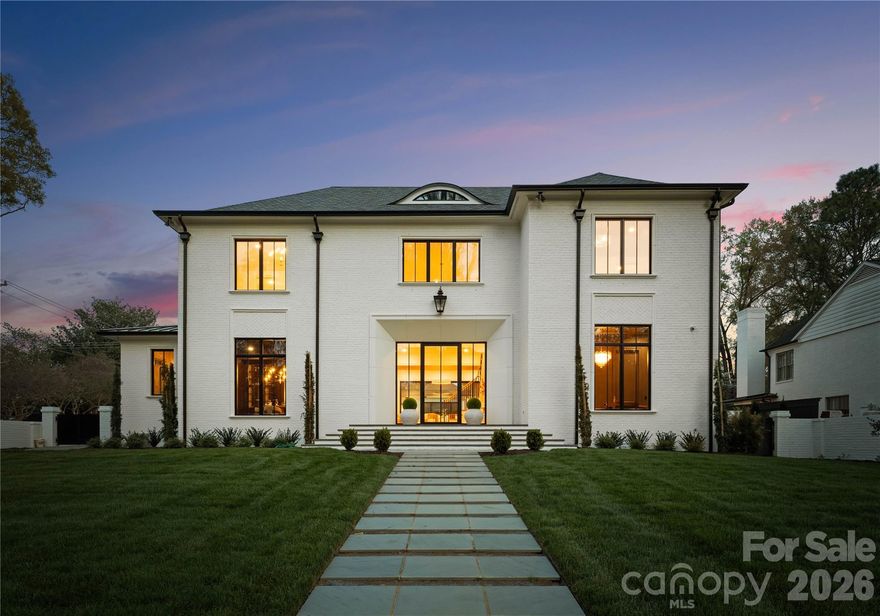 Experience an extraordinary level of luxury in the heart of Charlotte with this architectural showpiece, set on 0.53 acres and designed to impress at every turn. This full-brick, multi-generational estate features designer fiberglass shingles paired with a striking metal roof and offers an impressive 8,553 heated sq ft, including a private 776 sq ft guest/in-law/teen residence. A rare offering, the property showcases two architecturally distinct homes seamlessly blended for elevated living and grand-scale entertaining.

From the moment you arrive, every detail reflects intentional design and superior craftsmanship. A dramatic 10’ x 5’ glass and metal entry door welcomes you into 2 story tall foyer with a magnificent chandelier. The foyer offers the convenience of an elevator, and the interiors are defined by 12’ soaring ceilings, 10’ ceilings upstairs, and 10’ interior doors throughout. Rich 5” white oak hardwood floors flow seamlessly, while 4 linear gas fireplaces and 2 dual-fuel Isokern fireplaces create warmth and architectural drama. 
The heart of the home is a true culinary masterpiece—featuring dual waterfall quartzite islands surrounded by soft-close cabinets and drawers, spice racks, premium appliances, an extraordinary custom-built and designed hood, and an effortless flow into the breakfast and family room, making the home a soul. A fully appointed scullery kitchen with a coffee station elevates hosting to a professional level. The formal dining room, complete with a designer wet bar and glass-front wine display, sets the stage for unforgettable gatherings.
Thoughtfully designed for modern luxury living, the home features a beautifully appointed mudroom with custom built-ins, workspace, and an integrated steamer in the laundry area. Expansive windows flood the home with natural light, accentuating tall ceilings and statement lighting throughout. A flex/bedroom/study room with an electric fireplace on the main level.
The primary suite is a private sanctuary rivaling a five-star resort, featuring a spa-inspired bath wrapped in marble, a statement chandelier over the soaking tub, a seamless walk-in shower with spa-grade shower system, and an exceptional custom closet designed to showcase and organize a luxury wardrobe.

Upstairs, 4 spacious en-suite bedrooms and a loft with a wet bar provide both privacy and refined comfort for family and guests. Multiple laundry areas, including a dedicated guest suite laundry, ensure effortless daily living.
Step outside into your own private resort—where every detail is designed for elevated living and effortless entertaining. A heated saltwater pool and spa create a serene focal point, complemented by a fire pit and an expansive covered patio featuring a gas fireplace and a wet bar with counter space. This is indoor-outdoor living at its absolute finest.

 A dedicated wellness retreat offers a true at-home spa experience. Thoughtfully designed with custom cabinetry, a beverage station and ample counter space for your Vitamix, the space flows seamlessly into a private gym and yoga studio. A dry sauna, steam shower, and full bath complete this tranquil escape—bringing daily rejuvenation right to your doorstep.


The full brick fenced wall around the grounds, with an irrigation system are equally impressive, featuring four custom metal louvered gates, cedar herringbone garage doors, energy-efficient metal exterior doors with digital locks, and a comprehensive surveillance system. Professionally designed landscaping, a unique concrete-designed driveway, and a striking wall fountain on the side complete the estate’s commanding presence.

This is more than a home—it is a statement of lifestyle, design, and distinction.