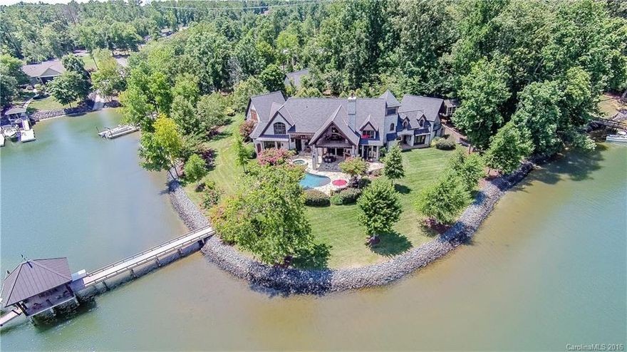 This distinctive estate sits on what seems like its own island on Lake Wylie shores. Consisting of a gorgeous 5,539 sf home which boasts chef's kitchen, extensive millwork, Cumaru hardwoods, master retreat, guest suite, media room & bell tower. Thoughtfully built w/every detail considered, the beautiful interior is rivaled only by extraordinary landscape, salt water pool, outdoor amenities, gated entry & the lake. A party dock anchors the 163 ft of lake frontage-ideal for entertaining.