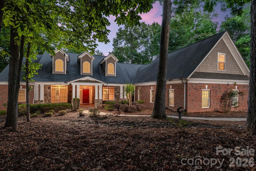 Tucked away on nearly 2 private wooded acres just minutes from the heart of Waxhaw, this exceptional custom residence offers the rare combination of luxury, privacy, natural beauty, and everyday convenience.  Overlooking a pristine shared pond with a private dock, this property delivers the peaceful lifestyle you may be looking for.  Thoughtfully designed for both entertaining and comfortable daily living, the home features over 4100 square feet with an open-concept floor plan.  The chef's kitchen serves as the centerpiece of the home with a Wolf gas cooktop, oversized GE refrigerator, double ovens, expansive island seating, and abundant gathering space ideal for hosting family and guests.  The great room is anchored by a stunning stone fireplace that creates warmth and character, while expansive windows frame the surrounding landscape and pond views.  The spacious primary suite offers a private sitting area, direct deck access, and tranquil water views.  The split bedroom design, provides ideal separation and flexibility, including an ensuite guest room, and additional bedrooms connected by a jack and jill bath.  The fourth bedroom used as an office, has custom built-ins, making it ideal for remote office space.  Extensive recent upgrades provide tremendous value and peace of mind.  In the past 2-3 years the home was converted to natural gas which included a new furnace, heat pump, AC units, and a whole house generator with a transferable warranty which will pass on to the buyer at closing.  All that combined with 22 new windows in 2026, a 40 year shingle on the roof, plus full house interior painting throughout, including the garage, makes this home move-in ready.  Luxury acreage with pond views, no HOA, and a level of convenience that is increasingly difficult to find.  This is more than a home, it is a lifestyle designed for buyers who value space, serenity, and timeless quality.