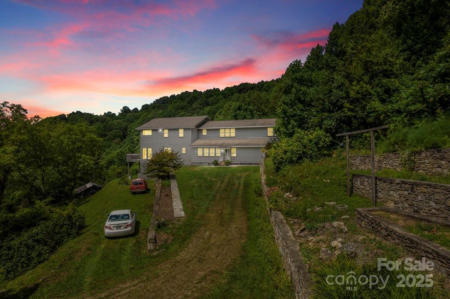 Don't miss this Mountain Paradise on 142.5 Acres. Nestled in pristine mountains, this land offers breathtaking views and serenity. Embark on daily hikes right on your property, discovering hidden spots and panoramic vistas. The private residence combines comfort with wilderness charm. The thoughtful layout with ample storage makes it an ideal mountain escape. The land holds logging potential and opportunities to revive pastures for farming. Bring your goats, cows, and chickens!  Natural springs dot the property, suitable for livestock. Beautiful stone terraces showcase craftsmanship. Just a 45-minute drive to downtown Asheville, experience the tranquil mountain life with city amenities close by.