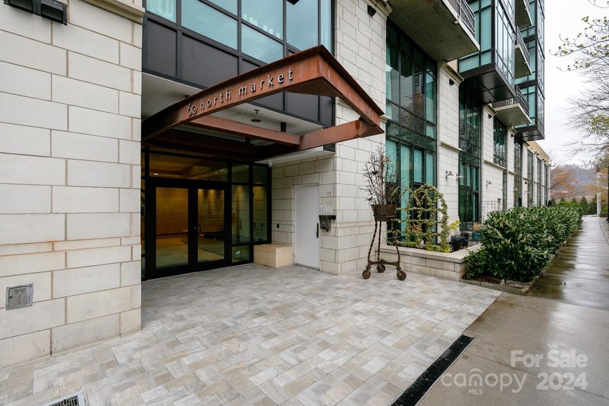 Be a part of Asheville's premiere downtown condo building, 60 N. Market Condominiums! This beautiful 1st floor condo has an open floor plan with a gas fireplace, bright dining nook and a wall of windows opening to a huge 200sf outdoor patio surrounded by trees. Wood floors, large closets with built-ins, laundry closet, stainless appliances and remote-controlled window coverings. Condo includes one dedicated parking space in the secure parking garage under the building. Owners share club room, outdoor patio with outdoor fireplace, common gas grill and fitness room. Condo is currently leased through November so is being sold fully furnished. Dues include cable, Internet, water and trash.