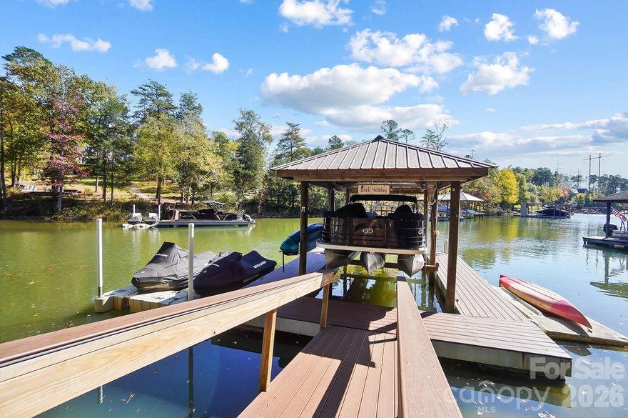 Experience the best of Lake Wylie living in this exceptional custom brick home, perfectly positioned on a wooded 2-acre, gently sloping waterfront lot that captures the essence of privacy, beauty, and craftsmanship. Nestled among tall Carolina pines with a tranquil cove setting just off the main channel, this property seamlessly combines the elegance of an estate with the comfort of a private retreat, all while being situated in a cozy neighborhood of Windswept Cove.

From the moment you arrive, the home’s stately presence and long drive through mature trees set a welcoming tone. Step inside to find a two-story foyer with gleaming hardwoods and an abundance of natural light streaming through oversized windows. The layout was designed for both daily living and entertaining — open, flowing, and filled with scenic views at every turn.

The main level features a spacious great room anchored by a stunning floor-to-ceiling stone fireplace and vaulted ceilings. The adjoining kitchen is a showpiece — beautifully updated with custom cabinetry, quartz countertops, stainless steel appliances, and a large island with seating. A butler’s pantry and formal dining room make hosting gatherings effortless. The sunroom with screen panels offers year-round enjoyment, showcasing the peaceful wooded backdrop with shimmering pool and lake views.

The home offers two primary suites, one located on the main level with lake views and deck access, while the upper level suite provides a restful retreat with tray ceiling and a spa-inspired bath. Both primary baths include dual vanities, a large walk-in shower, custom tilework, and wood flooring. Additionally, upstairs offers flexible living with two spacious bedrooms, a media/game room, perfect for movie nights or watching the big game. In contrast, others may enjoy the space as an office or cozy study.

The basement offers an additional bedroom, full bath, family room, a game day kitchen with a microwave and cooktop. Tons of storage and flex space currently being used as pool and game room, however, it can easily be converted to workshop area.

Outdoor living here is truly exceptional. Step out to a multi-level deck and enjoy the expansive space designed for both relaxation and entertaining. A pergola-covered sitting area, an open deck for grilling, and a sunroom with screens create the perfect atmosphere for evenings with friends, no matter the season. Below, the resort-style pool becomes the centerpiece — framed by tropical landscaping and surrounded by lounging areas that invite you to slow down and enjoy the view.

Follow the gently sloped concrete walkway down to your private waterfront, where lake life begins — complete with a circular stamped-concrete fire pit area, covered dock with boat lift, jet ski ports, and shaded seating area overlooking the lake. The cove provides easy access to the main channel, offering the best of both worlds: calm water for peaceful fishing and kayaking, or hop on your boat & jet ski to feel the breeze blowing through your hair with over 325 miles of shoreline to explore.

Every detail of this home speaks to quality and care — from the upgraded lighting, flooring, and custom finishes inside to the professional landscaping and well-maintained exterior.  Backup power generator for uninterrupted convenience and peace of mind. It’s the ideal balance of sophistication and comfort, designed for those who appreciate the lake lifestyle!

Located in the highly sought-after Clover School District, this home offers low South Carolina taxes while providing convenient access to Charlotte, shopping, dining, and medical facilities. Charlotte Douglas International Airport and Uptown Charlotte are just a short drive away, yet life here feels far removed from the city — peaceful, private, and distinctly lakefront.

This is more than a home — it’s a lifestyle destination, where every season brings new opportunities to entertain, unwind, and make memories by the water.