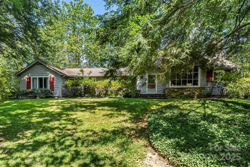 Beautiful and timeless 3BR/3BA home on 1.25 acres in coveted Biltmore Forest! This serene property offers multiple outdoor spaces for enjoying both sun and shade in a peaceful setting. Inside, you’ll find an open-concept kitchen/living area with gas log fireplace, built-ins, breakfast bar, and dining nook. The expansive Great Room features a cathedral ceiling, wood-burning fireplace, and versatile layout perfect for entertaining and formal dining. A separate bonus room adds flexible living space for recreation, media, and more. The primary suite includes two walk-in closets plus private bath with dual vanities, garden tub, and walk-in shower. The second bedroom connects to a full bath; the third bedroom features a warm rustic feel and dual closets. Plenty of storage throughout, including a walk-in attic and unfinished basement. Large driveway with turn-around and ample parking. A rare gem in one of Asheville’s most desirable neighborhoods!