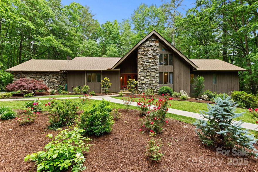 Spectacular completely renovated home with luxury amenities situated on 3.7 acres of absolutely gorgeous landscaping with the utmost in privacy. The main level boasts a dramatic entry leading to an expansive dining area and great room with soaring floor to ceiling see-thru stone fireplace and wall of windows. The professional chef’s kitchen boasts high-end appliances and abundance of cabinets with Taj Mahal quartzite tops, stone backsplash, 2 islands, coffee bar, wine cooler and breakfast area, primary suite w/ fireplace, 2 walk-in closets, double vanity w/ stone vessel sinks, jet tub and walk-in shower, powder bath with designer sink, guest BR with ensuite BA, laundry room w/ sink and cabinetry. The upper level makes a great study and bonus space. The lower level features family room with stone fireplace, rec room, guest bedroom/bath and studio. Huge unfin/storage space. Experience outdoor luxury living on the deck w/ cable railing or the patio. Prime location-minutes to downtown