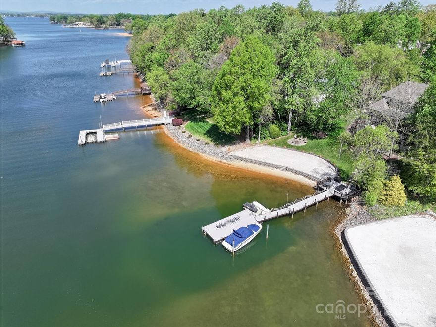 Lake Norman Luxury in Patrick’s Purchase

Discover a rare chance to embrace the ultimate Lake Norman lifestyle in the highly sought-after Patrick’s Purchase community. This stunning waterfront home offers over 4,700 square feet of thoughtfully updated living space with 5 bedrooms, 5.5 baths, and a perfect mix of classic craftsmanship and modern touches.

From the moment you arrive, the home impresses with a stone façade, shutters, a newly paved driveway, and professionally landscaped grounds. Inside, soaring cathedral ceilings in the great room, anchored by a dramatic stacked-stone fireplace, set the stage for effortless gatherings. Custom wainscoting, rich built-ins, and elegant upgrades throughout add warmth and sophistication.

The chef’s kitchen is built for both cooking and entertaining, featuring Wolf and Sub-Zero appliances, granite countertops, and custom cabinetry. Whether it’s holiday dinners, weekend brunches, or casual nights on the porch, the home’s flow makes every moment memorable.

Outdoor living here is just as impressive. Enjoy the screened porch with fireplace, expansive deck, outdoor kitchen, and paved patio, perfect for year-round enjoyment. Step down to your private dock for boating, fishing, or soaking in the water views, or relax on your rare sandy beach—ideal for swimming, paddleboarding, or simply letting your toes sink into the sand. A recent site survey confirms this property is pool-ready, offering the opportunity to create your own resort-style backyard retreat.

Behind the beauty, practical upgrades provide peace of mind: a 2018 roof and gutters, 3-zone Trane HVAC, 85-gallon high-capacity water heater (2021), updated bathrooms and laundry (2016), freshly installed carpet (2022), and a professionally sealed crawlspace for efficiency. Two bonus/game rooms and a spacious 3-car garage add versatility and storage for all your needs.

What makes this home truly special is the lifestyle. Mornings start with coffee on the water, afternoons flow with boating or swimming from your backyard, and evenings end with cocktails by the outdoor fireplace against stunning Lake Norman sunsets. Whether you’re creating family memories, hosting friends, or enjoying the lakefront lifestyle, this home delivers a rare combination of comfort, elegance, and unforgettable views.

Set on one of Patrick’s Purchase’s most prestigious streets, this is more than a home—it’s a legacy property designed for generations to enjoy.

A survey site plan has been done to confirm a pool can be added. see all attachments