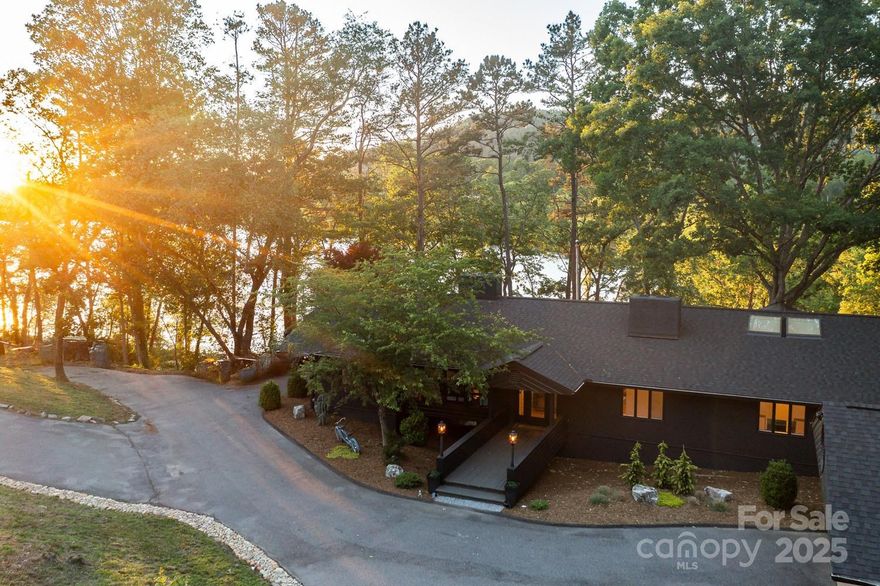An extraordinary opportunity to own one of few lakefront homes on coveted Beaver Lake. This fully reimagined 5BD/3.5BA contemporary retreat offers over 289 feet of shoreline and direct access to the walking trail in the heart of North Asheville. Clean architectural lines, soaring ceilings, and expansive windows create seamless indoor-outdoor living with tranquil lake and mountain views from nearly every room. Tucked beyond a short, steep driveway—your private entry to this hidden sanctuary—this home rewards with serenity, space, and natural light. Enjoy over 1,000ft of tiered decks and patios, a screened porch for morning coffee, and a luxurious main-level primary suite with sunset views. The open living area includes a dramatic 15-ft waterfall island and skylit ceilings. Downstairs features a cozy book nook, second primary suite, and flex space for fitness or play. Minutes from downtown, this rare lakefront gem offers an elevated Asheville lifestyle. Owner is licensed NC Broker.