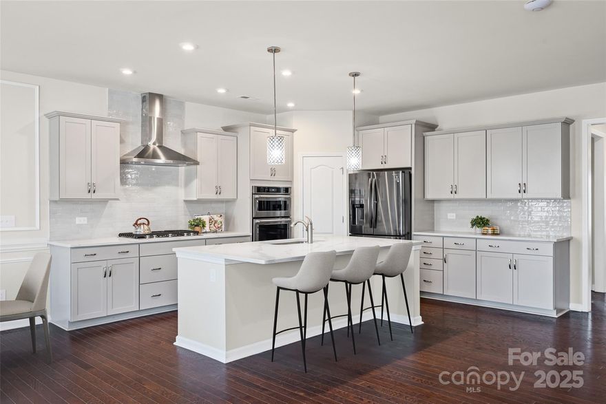 This showstopper chef's kitchen has brand new quartz counters and an expansive island, new tile backsplash, new stainless steel vented hood, gas range, and walk-in pantry - you won't want to miss this transformation! As you make your way in on stunning wood floors, the custom finishes throughout will impress you - shiplap, entryway built-ins, designer lighting, and more! The open & bright great room flows into the backyard, w/ an expanded paver patio w/ sitting wall & lights (over 400 sqft), and an elevated lot with long range views. Also downstairs is a bedroom & full bathroom with walk-in tiled shower, flex area, tons of storage closets, & garage w/ epoxy floors. Upstairs are another 3 bedrooms including a generous primary, 2 bathrooms, large loft, & laundry room. Too many upgrades to mention, incl landscape lighting, security system, fridge & W/D convey - see attachment for full list! McCullough is a lifestyle rich community w/ 2 pools, sport courts, dog park, near downtown Pineville, & 10 min from a light rail stop that takes you straight to uptown - welcome home!