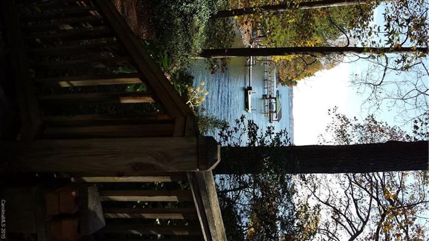 LKN Waterfront home on 2 acres. Peaceful retreat Wooded lot, fruit trees, blueberries. Certified wildlife sanctuary. Covered boat slip w/lift, 2 jet ski lifts, deck, year round water No HOA Open floor plan w/large kitchen area w/breakfast area and sunroom. Open dining room allows for extending the table for large gatherings. Beautiful floor to ceiling stone fireplace w/built ins. Unheated finished room over garage. Large detached building currently a shop with storage has endless possibilities.