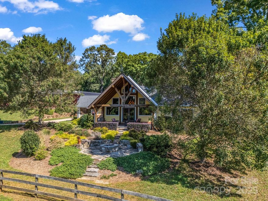 PRICE IMPROVEMENT!!  Welcome to Back Stretch Farm—where country charm blends seamlessly with practical equestrian living in scenic Tryon, NC. Nestled on 20 gently rolling acres with direct F.E.T.A. trail access, this property is a dream for horseback riding and outdoor adventures. Surrounded by conservation lands protected from future development, Back Stretch Farm offers unmatched privacy and lasting natural beauty.
The custom post-and-beam hybrid home features 3 inviting bedrooms, 3 full baths, and warm, sunlit gathering spaces designed for family and friends. A custom-designed barn includes 4 stalls, a center aisle, a workshop, and generous equipment and hay storage.  A conditioned tack room with full bath, laundry and living accommodations.  A second barn offers a run-in shelter that could easily be enclosed to create additional stalls.
Fenced and cross-fenced pastures include additional run-in shelters, ideal for horses and hobby animals. For competition riders, an all-weather footing  arena provides year-round training opportunities, while the wooded sections of the property promise peace, seclusion, and room to explore.
Located just minutes from the welcoming town of Tryon and the world-class Tryon International Equestrian Center, this rare offering combines the best of country living with proximity to top equestrian events. Back Stretch Farm is a unique horse-country haven—schedule your visit today and experience its charm for yourself.