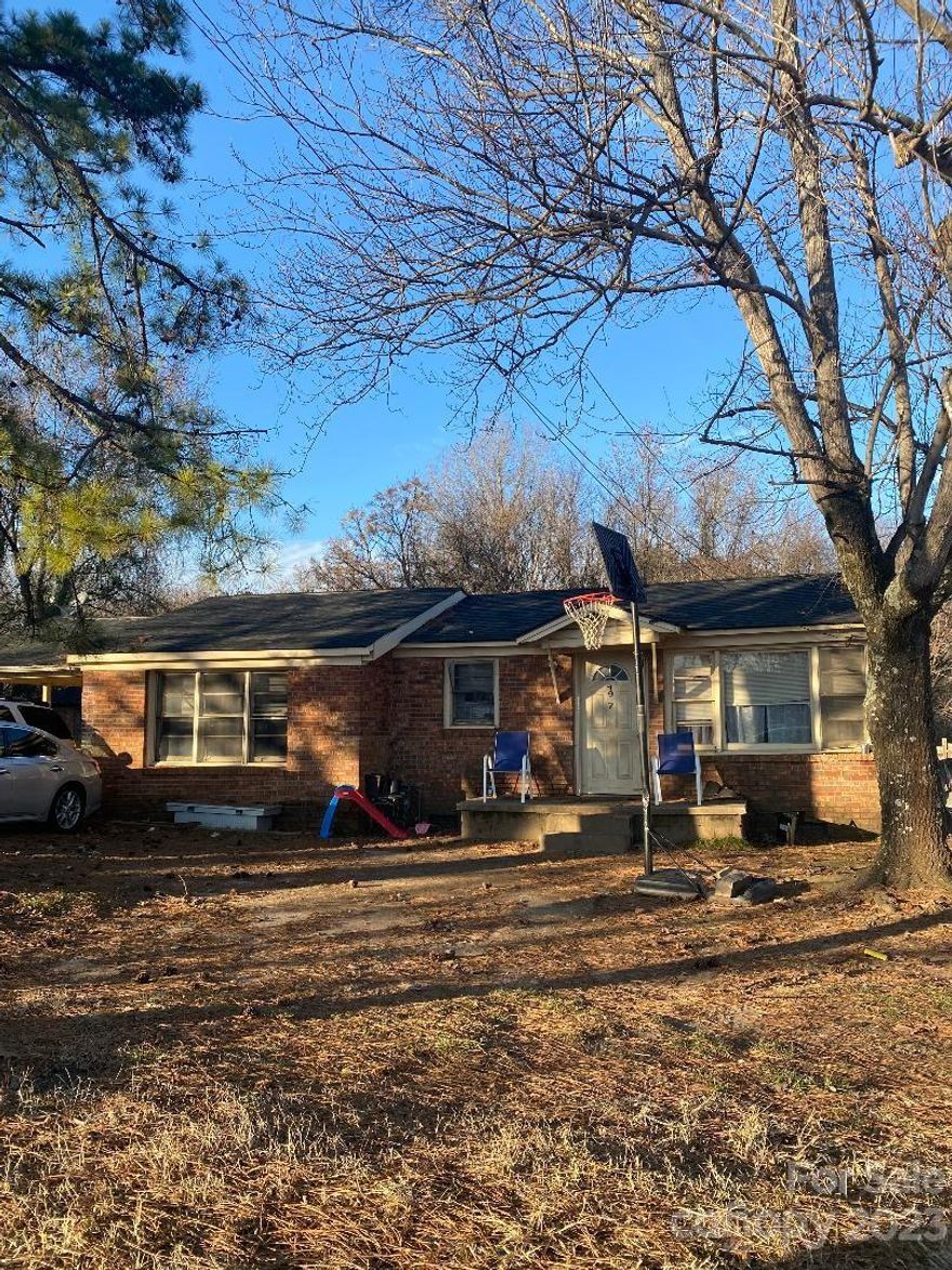 Brick, 3 bedroom, 2 bath, with single carport house with city sewer and city water. Laundry is in utility room at carport. This property is occupied with tenant who has been there for a long time.  Make appointments through Showing Time.  Lease is now a month to month.  No showings without appointments.  There is another house on this lot with separate sewer and water connections from city of Statesville.  Two bedrooms, one bath, and has been rented for many years to the same tenant,  No showings without appointments through Showing time.  Sq footage of this house is 520 sq ft., designated parking space. No laundry in second property.    Back yard is shared by both houses.  Both properties need work cosmetically. Roofs were installed three years ago.