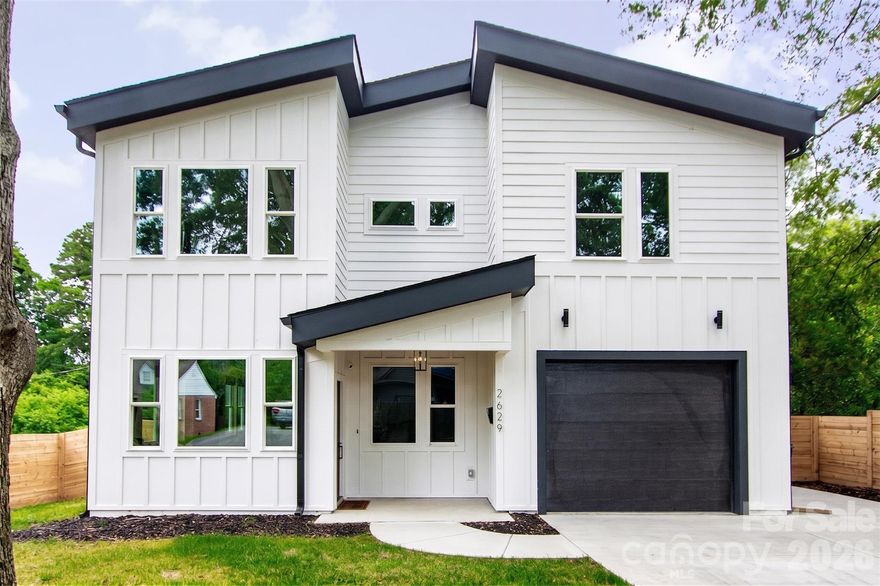 Here’s your chance to own a like-new home in thriving Revolution Park! Located just minutes from South End & Uptown, enjoy exceptional convenience to some of Charlotte’s best dining, entertainment, and employment hubs. Built only a few years ago and meticulously maintained, this modern residence blends luxury, functionality, and an unbeatable location. The light-filled open concept design is an entertainer’s dream, showcasing timeless contemporary finishes throughout. The stunning kitchen features a gas range, quartz countertops with a large waterfall island, custom hood vent, and a spacious walk-in pantry. A stylish wet bar with beverage cooler seamlessly connects to the living area, where a cozy fireplace creates the perfect place to unwind or gather. The expansive primary suite impresses with a spa-inspired bath, complete with soaking tub, walk-in shower, and generous closet space. Secondary bedrooms are well-sized with ample storage, and each bathroom showcases custom tile work and thoughtful design. Since construction, the current owners have added standout and versatile mixed-use sport court/basketball area, perfect for recreation, fitness, and entertaining. It has also been enhanced with a mini-split system creating a fully conditioned space in the insulated garage making ideal for a gym, workshop, or flex use.
Enjoy outdoor living on the covered rear patio overlooking the fenced backyard. With its blend of modern design, upgraded amenities, and prime location, this home is perfectly suited for how you live, work, and play.