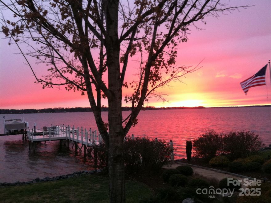 Experience lakefront living at its finest on Lake Norman! This exceptional 3-bedroom, 2.5-bath waterfront home captures the essence of lake life with nearly 200 feet of pristine shoreline and soaring, long-range sunset views from one of the most desirable gated communities off Langtree Road. From the moment you arrive, the setting feels private and inviting, surrounded by mature trees, gentle lake breezes, and endless water vistas. Inside, a dramatic two-story great room welcomes you with expansive windows that frame the lake from every angle, filling the home with natural light. The open concept seamlessly connects the main living area to the screened patio and outdoor entertaining space, complete with a cozy stone fireplace, perfect for year-round relaxation and gatherings with family and friends. The main floor primary suite offers a serene retreat, featuring a fully remodeled bath with heated floors, custom tilework, and thoughtful design details. Upstairs find an expansive loft, perfect for office space which leads to an upstairs patio with lake views for miles. Two additional bedrooms, each positioned to take advantage of the tranquil lake views, and a bonus/bedroom provide flexibility. Throughout the home, Bahama wooden shutters add timeless island-inspired character, blending coastal charm with refined style. An upgraded stationary deep water dock and sitting area extends the outdoor lifestyle, ideal for boating, swimming, or simply enjoying your morning coffee while watching the sunrise over the water. In addition, seller would consider selling the adjoining .64-acre lot, offering over 150 feet of shoreline and a grandfathered 35-foot setback. This extremely rare feature allows future construction closer to the water than current regulations permit. This additional parcel provides an opportunity to expand your waterfront footprint, create a family compound, or build an additional lakeside home. Located just minutes from I-77 and Langtree at the Lake, this property combines quiet waterfront living with unbeatable convenience, close to restaurants, shops, and the vibrant Lake Norman lifestyle. Whether you’re seeking a full-time residence or a weekend retreat, this one-of-a-kind property delivers the best of both worlds: privacy, luxury, and the beauty of Lake Norman right at your doorstep.