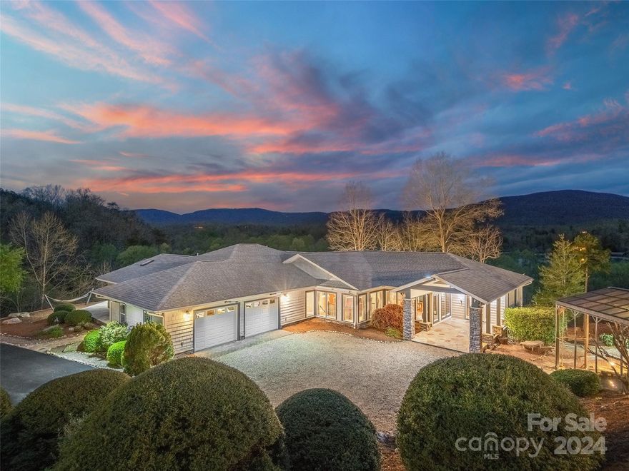 Welcome to your private lakefront oasis nestled on 2.55 acres along the shores of Lake Adger. Beyond a gated entrance, discover a secret haven with outstanding views of the surrounding mountains and breathtaking sunsets. This exceptional property boasts direct access to Lake Adger and the Green River, plus a deeded boat slip at the South Marina. Indulge in resort-style amenities, including a heated in-ground pool for year-round enjoyment, a charming screened gazebo for dining al fresco, plus a peaceful koi pond and waterfall. Gather around the fire pit on cool evenings or retreat to one of the multiple outdoor seating areas offering a unique perspective of the endless natural beauty. This completely updated home offers teak hardwood floors, updated kitchens, and abundant windows with views from nearly every room! The main level primary suite opens to a private deck and leads down to your own kayak launch. Plenty of space for guests and lakefront fun. Check out the video virtual tour!