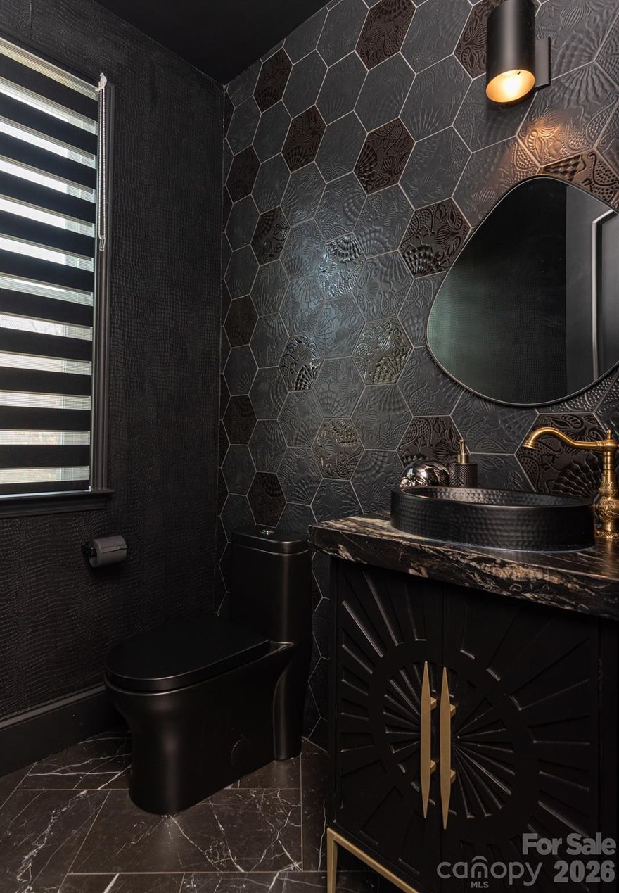 Lease Purchase available!  An exceptional, design-forward residence in the desirable Davidson, this beautifully curated 4-bedroom, 3.5-bath home with two primary suites offers a rare combination of architectural detail, elevated finishes, and thoughtful functionality across three expansive levels. A 2-car garage and extended driveway accommodating up to six vehicles provide uncommon convenience for entertaining and daily living. From the moment you enter, craftsmanship and intention are unmistakable. Custom flooring, oversized baseboards, and crown molding create a cohesive, upscale aesthetic throughout, complemented by dramatic accent walls, tailored millwork, and layered lighting. Smart home features throughout and EV charging plug. The statement powder room is a true showpiece, featuring bold, textured tile, a custom vanity with brass accents, sculptural lighting, and rich, moody finishes-more reminiscent of a boutique hotel than a private residence. The open-concept main living level is anchored by a chef-inspired kitchen with granite countertops, stainless steel appliances, soft-close cabinetry, and a generous island with designer pendant lighting—ideal for both entertaining and everyday living. Just beyond the kitchen, a dedicated scullery offers additional prep space, custom cabinetry, open shelving, and storage-perfect for small appliances, coffee stations, and keeping the main kitchen effortlessly polished. Living spaces are equally refined, featuring a custom media wall, modern fireplace surround, and architectural wood detailing that adds warmth and texture. Large windows bring in abundant natural light, while designer window treatments and curated finishes maintain a polished, intentional feel. Both primary suites serve as private retreats, one on 1st level and one on 3rd level, each thoughtfully designed with private bathrooms, custom walk-in closet system offers boutique-level organization and storage. Additional bedrooms provide flexibility for guest suites, home offices, or creative spaces. Outdoor living is seamlessly integrated with a screened-in porch, creating a tranquil extension of the home-perfect for morning coffee or evening relaxation. Throughout the home, energy-efficient systems enhance comfort while supporting modern living. Situated just minutes from downtown Davidson, this residence offers effortless access to the farmers market across the street, boutique shopping, acclaimed dining, Davidson College, 1-77, Lake Norman, and Charlotte-while delivering a refined, private retreat unlike others in the area.