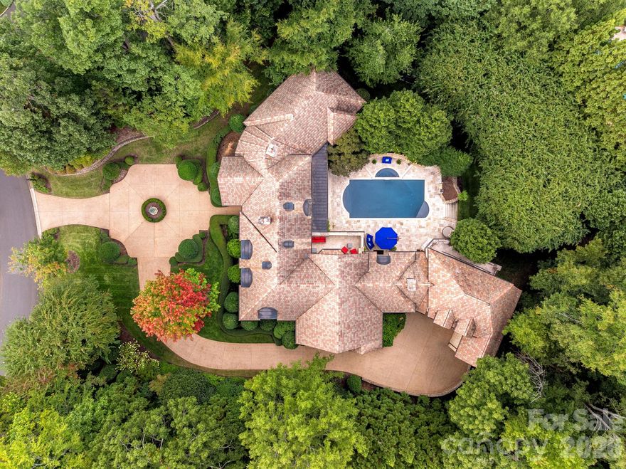 A rare Old World estate reintroduced to the market, gracefully set within the prestigious, gated Morrocroft community. This architecturally rich residence blends enduring European influence with thoughtful modern refinement, beginning with a striking stone façade and classic terracotta roof that create immediate presence and distinction.

Upon arrival, heated flooring welcomes you into interiors defined by warmth, scale, and impeccable craftsmanship. Natural stone, fine millwork, and elevated finishes are seamlessly paired with contemporary design elements, creating spaces that feel both timeless and current. Every detail has been curated to deliver comfort, sophistication, and effortless livability.

The chef’s kitchen is a true centerpiece—designed for both daily living and elevated entertaining—featuring top-tier appliances, generous prep and gathering spaces, and a private wine cellar complemented by a Sub-Zero wine refrigerator, ideal for the discerning collector.

Indoor living transitions beautifully outdoors to a private resort-style retreat. A sparkling in-ground pool and spa are anchored by an inviting cabana bar, while lush, mature landscaping creates a tranquil backdrop and exceptional privacy for entertaining or quiet relaxation.

The home continues to impress with amenities, including a full private gym with sauna and adjoining bath—offering a true wellness experience without leaving home. Automobile enthusiasts will appreciate the three-car garage thoughtfully designed to accommodate two-car lifts, providing flexible storage for a prized collection.

Truly one of one, this estate stands apart from the surrounding homes and from much of what Charlotte has to offer—crafted without compromise and impossible to replicate. As distinctive as the individuals drawn to it, this residence is a singular expression of architecture, lifestyle, and presence. An opportunity rarely available in today’s market.