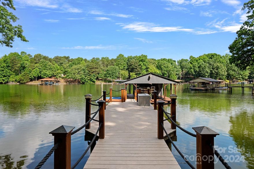 Welcome to your slice of paradise on the shores of Lake Norman. Tucked in a quiet cove, close to the main channel, this Brick Ranch/Bsmnt home features a primary bedroom on the main level. The split plan ensures privacy, with 2 more bedrooms on the opposite side of the home. At the heart of the house is a well-appointed kitchen, offering ample counter space, cabinets, & pantry. The great room, centered around a gas fireplace, provides stunning lake views. The basement combines finished & unfinished areas, including two additional flex rms (used as BRs), full bath, family & rec rooms, and access to a lovely, lakeside screened porch & hot tub. A kitchenette & laundry comprise one of the unfinished sections, plus the abundant storage space. The shed is equipped with electricity, heating, a/c, & a half bath. For RV enthusiasts, there is a 50-amp hookup, water and sewer connections. The covered floating dock comes with a lift. The pier, ramp & back deck have been updated with Trex decking.