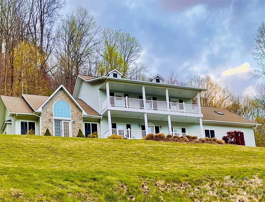 Love the mountains? Then, this stunning Maggie Valley home is for you!  It checks a lot of boxes -- privacy, mountain view, porches, decks, patio, fenced yard, ample parking, proximity, space and elegance -- we could go on.  Relax and feel the cool mountain breeze while you have your morning coffee or evening drink on the front porch.  Spacious accommodations include four bedrooms, two dining areas, two full baths, and two half baths.  Brazilian hardwood provides a classy elegance and warmth to the entire main floor.  Inset cabinets, bookshelves, device nooks, and even ceilings, display the quality craftsmanship that makes this place special.  Have sore muscles?  Enjoy the outside hot tub or the inside jacuzzi.  Planning dinner for a crowd?  Good thing you have two full ovens.  Need places for them to sit?  Choose from a formal dining room, an informal breakfast nook, a couple of seats at the kitchen bar, of plenty of extra seating out back on either the inside screened porch or outside patio and deck.  Need places for them to relax after dinner?  Try the family room or the spacious den, both on the main level, or the large "whatever you want it to be" room on the upper level.  Too many folks to fit on the front porch after all the fun?  No problem -- you have two of them -- one on the main level and a balcony porch running the length of the house on the upper level.  Add in a spacious two-car garage, with extra outside parking, and you really do "have it all".  Come see for yourself!  This home is part of the Fisher Ridge community.