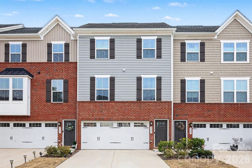 Welcome to this stylish three-story townhome in the desirable Grantham Place community in Fort Mill, offering modern design and a vibrant lifestyle in a highly convenient location. The exterior features a classic mix of brick and siding that gives the home great curb appeal while maintaining a clean, contemporary feel within the neighborhood setting.

Inside, the main level showcases a bright open layout designed for comfortable living and entertaining. The spacious living area flows seamlessly into the dining space and kitchen, highlighted by a large center island that creates a natural gathering place. Large windows bring in plenty of natural light, while modern finishes and stylish details throughout give the home a polished, upscale feel.

The upper level includes the primary suite along with additional bedrooms, offering flexibility for guests, home offices, or hobbies. A lower-level recreation space provides even more versatility, perfect for a media room, workout area, or second living space.

Outdoor living continues with both a deck and patio area, creating great spaces to relax or entertain while enjoying views of the surrounding neighborhood. Residents of Grantham Place enjoy a wide range of community amenities including a pool, cabana, dog park, playground, sport court, tennis courts, and scenic walking trails that wind throughout the neighborhood.

Located in the highly sought-after Fort Mill area, the home is just minutes from shopping, dining, and everyday conveniences, with easy access to I-77 for commuting into Charlotte. The area is also known for its highly regarded schools and close proximity to outdoor recreation, making it a wonderful place to live, work, and explore.